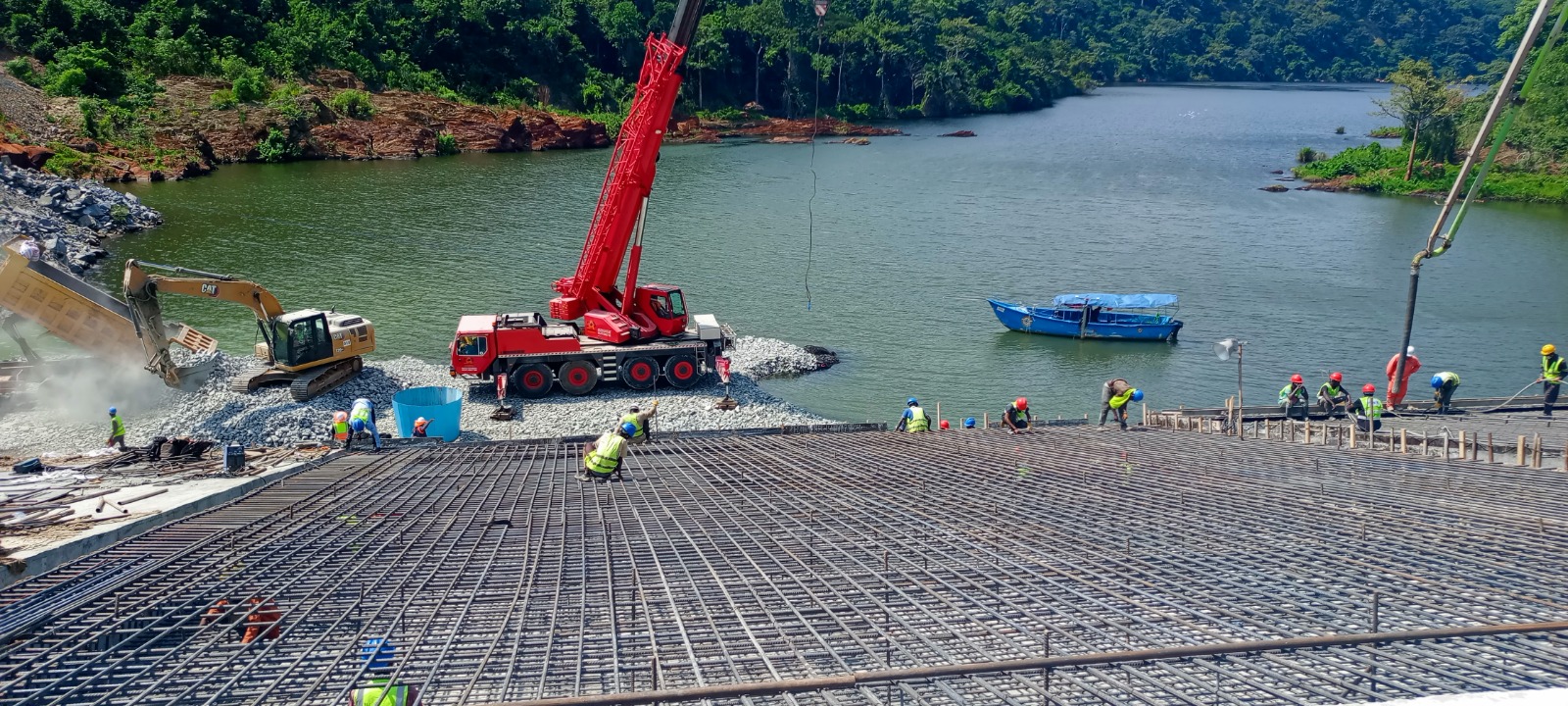 Construction crew working across a reinforced concrete section at the dam