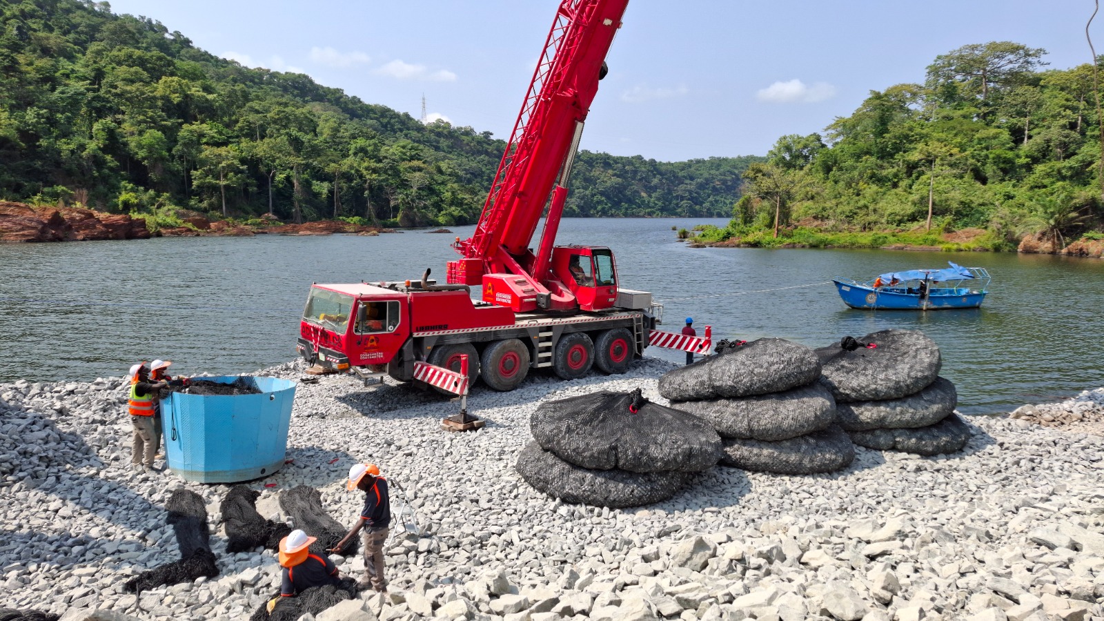 Adlerfields crane and crew preparing large rock bags beside the reservoir