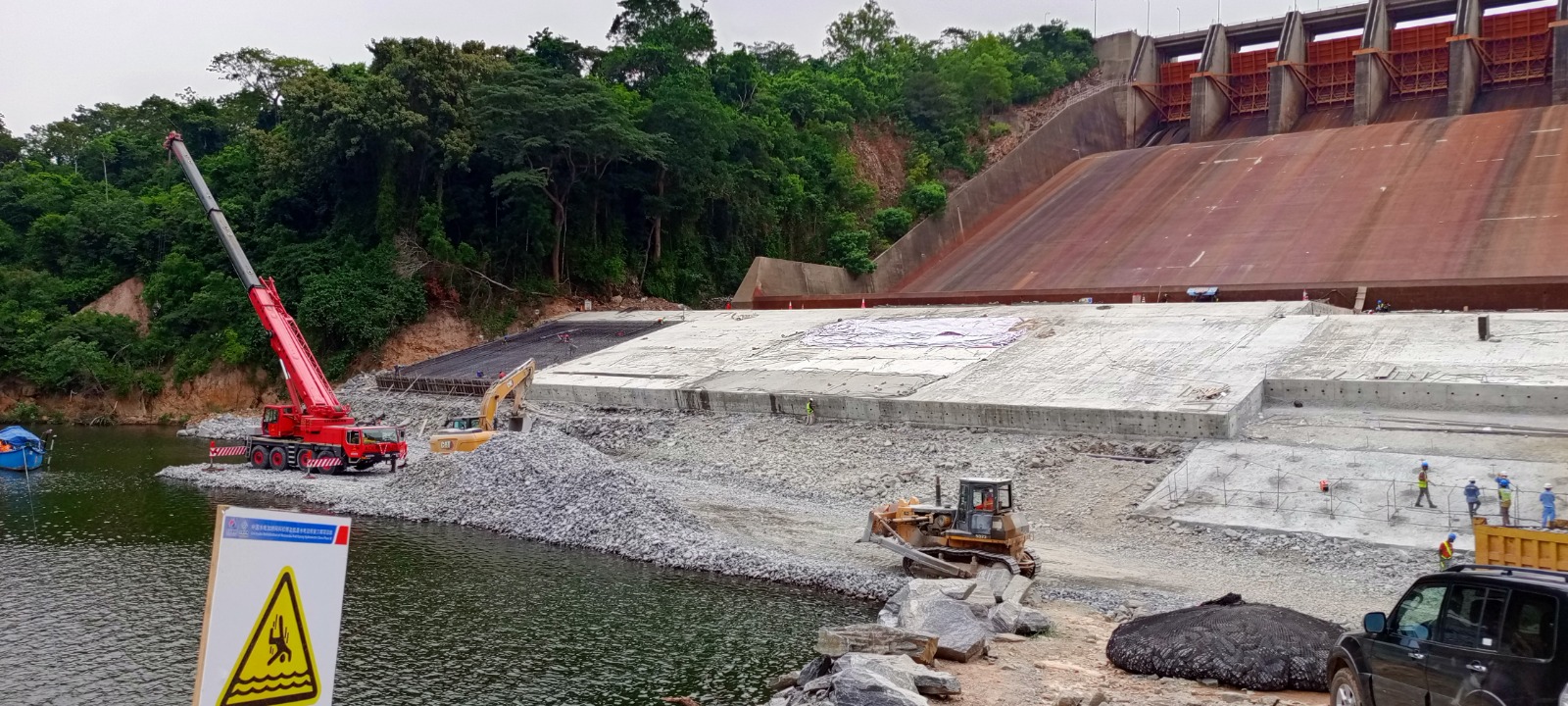 Wide view of Adlerfields' crane and site equipment working below the Akosombo Dam spillway