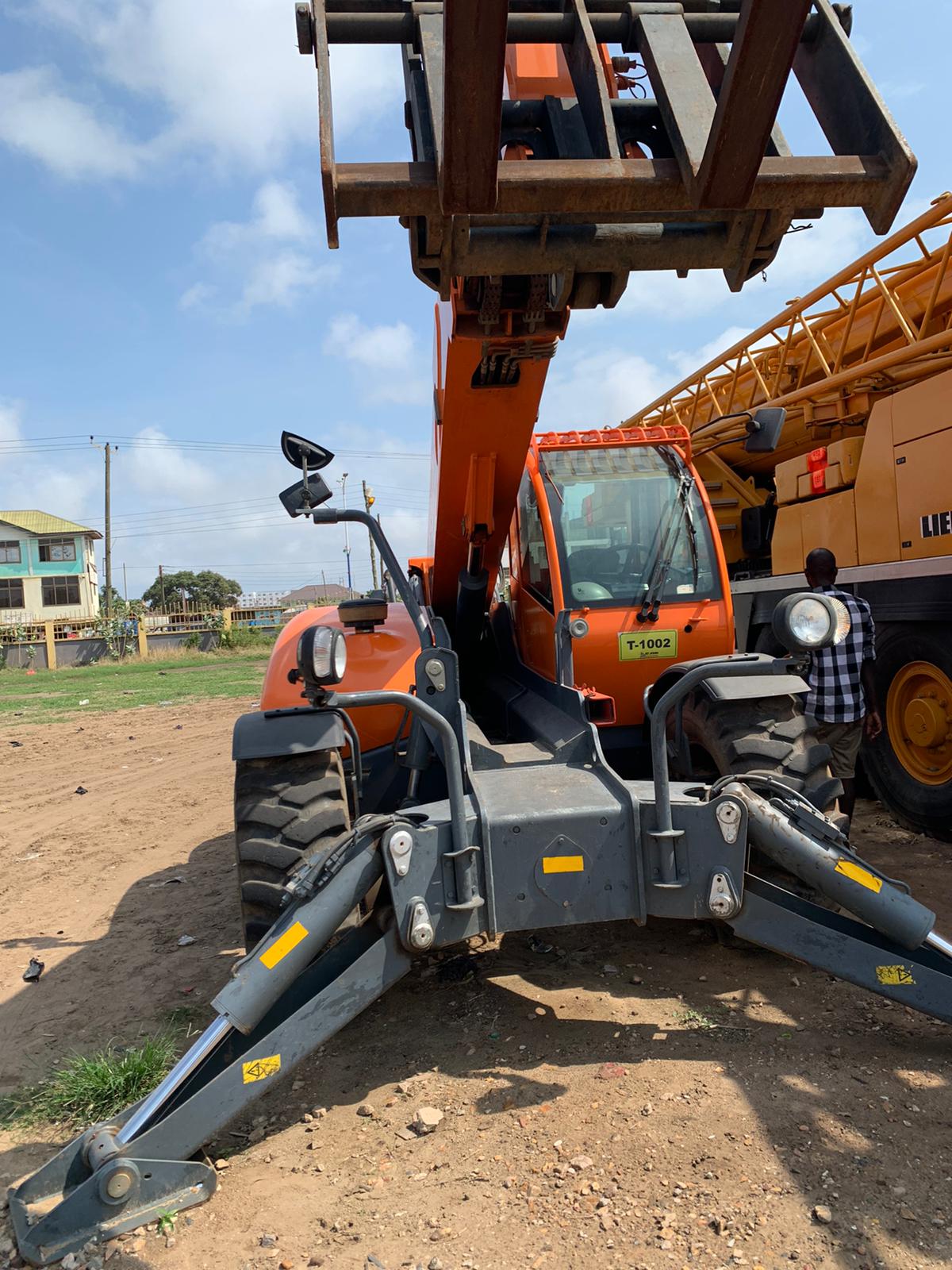 Orange telescopic forklift with stabilizers extended
