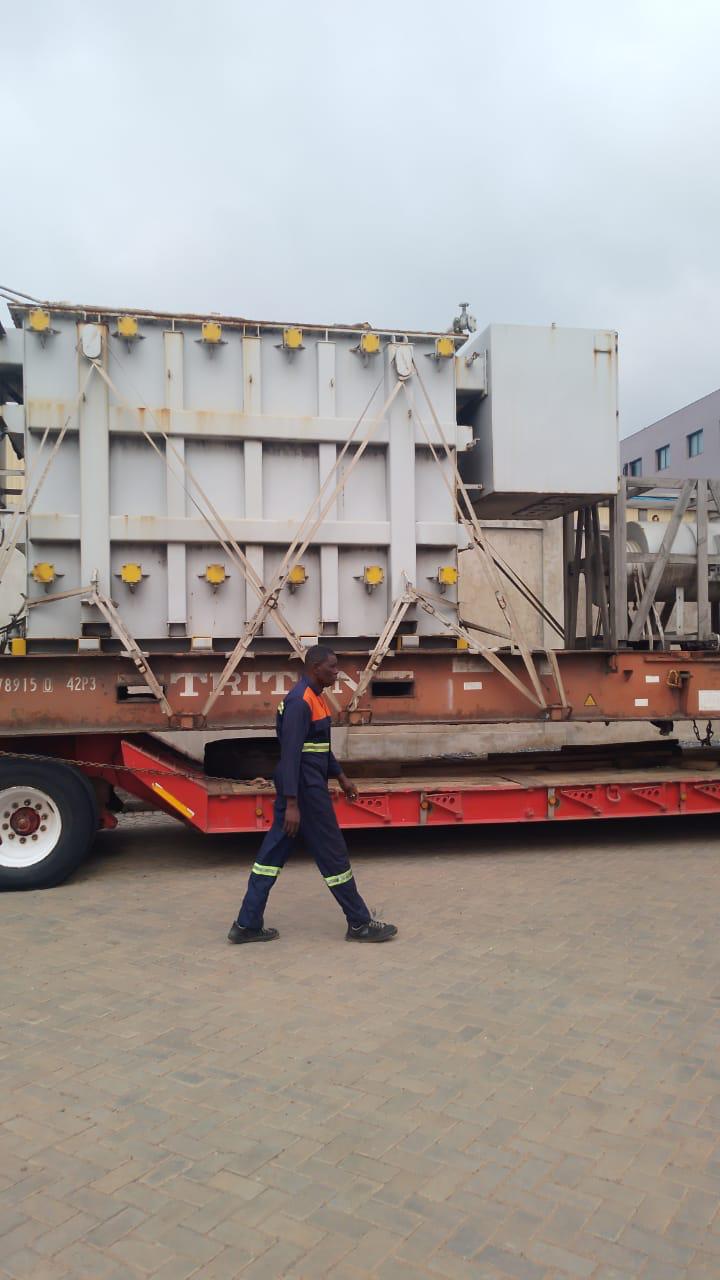Worker in high-visibility clothing beside secured industrial equipment